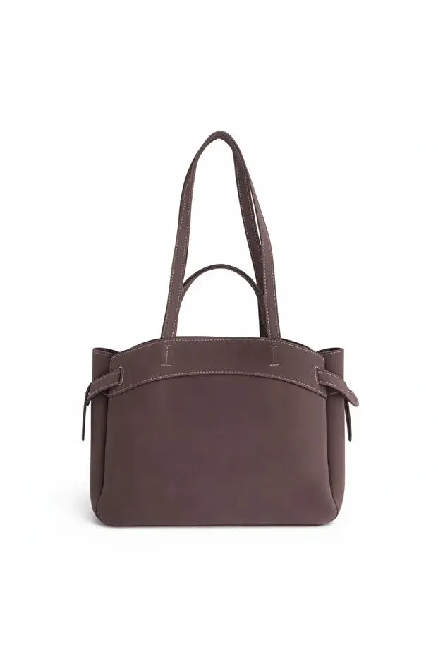 Duže ručke omogućuju udobno nošenje na ramenu, dok dekorativne bočne trake dodaju profinjen detalj.