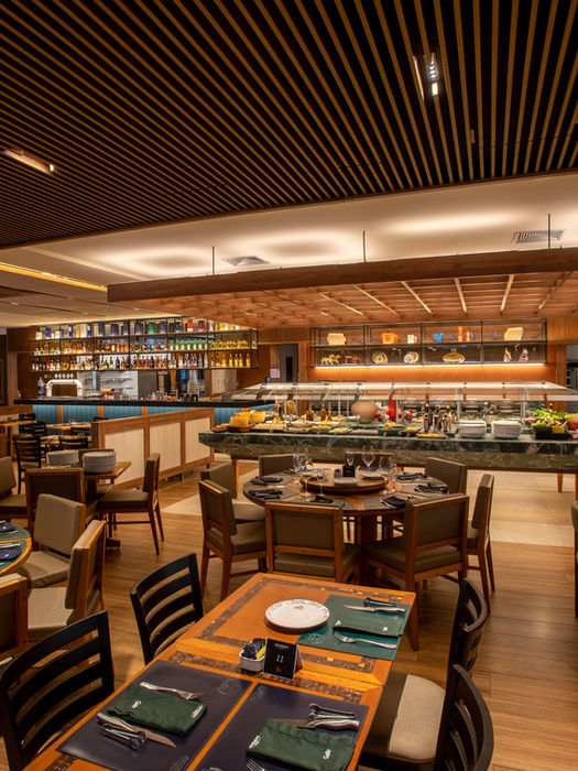 Restaurante interno com mesas, buffet e iluminação ambiente. cruzeirosprime
