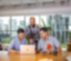 Colaboradores reunidos, analisando dados em laptop