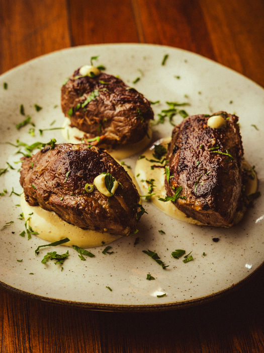 Três medalhões de carne grelhados sobre purê de batata, prato gourmet bolovo
