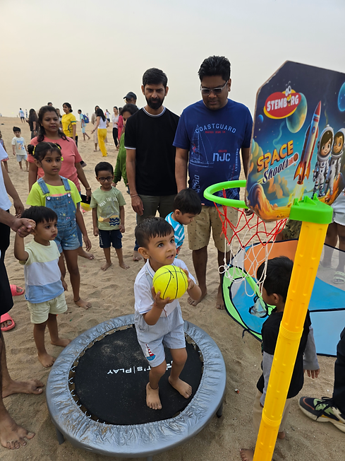 Child playing basketball on trampoline at JuniorFit beach event