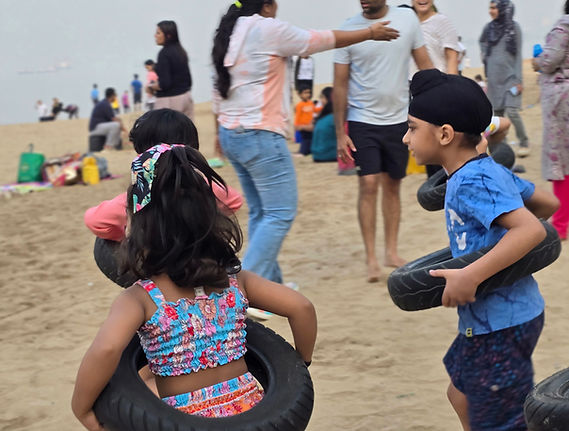 Children playing with tires on beach during JuniorFit beach playdate