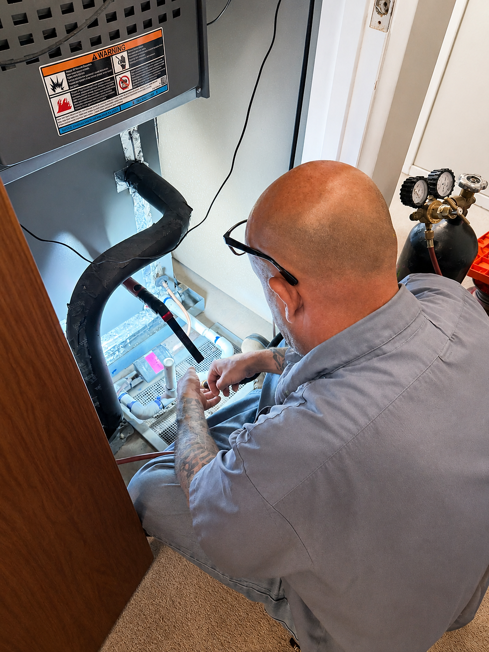 Day & Night Heating & Cooling owner Johny Aragon performing residential HVAC system maintenance.