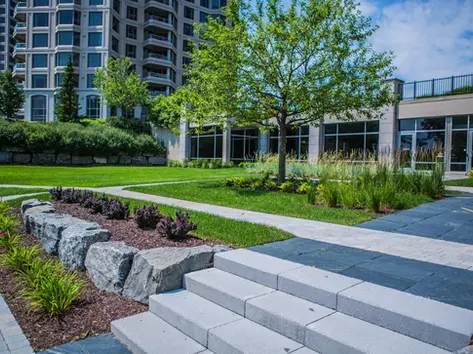 Aménagement paysager du Condominium Les Sommets sur le Fleuve à l'Île-des-Sœurs avec sentiers pavés, arbres matures, massifs végétalisés et espaces verts haut de gamme. – Richard Bélisle Architecte paysagiste Île-des-Soeurs