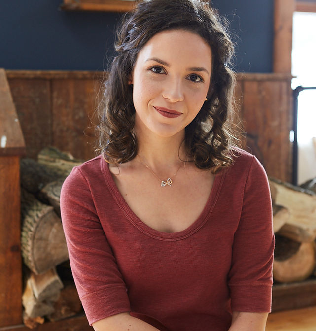 Caucasian girl with dark hair in a red shirt sitting on a step inside a house