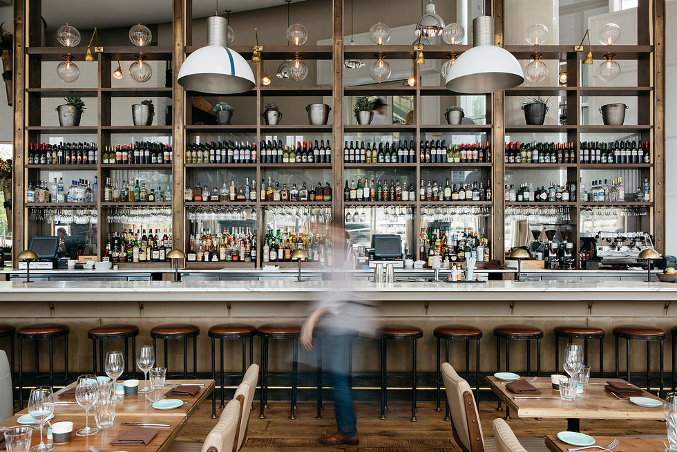 Großzügiger Gastronomieraum mit langer Bar, Sitzgruppen und wiederkehrenden Einrichtungselementen zur Gliederung verschiedener Nutzungsbereiche.