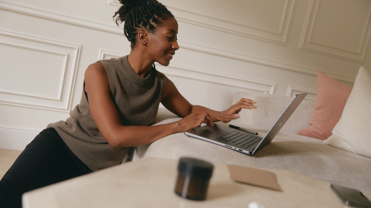 Selbstständige Interior Designerin arbeitet am Laptop und organisiert ihren Arbeitsalltag in einem modern eingerichteten Raum.