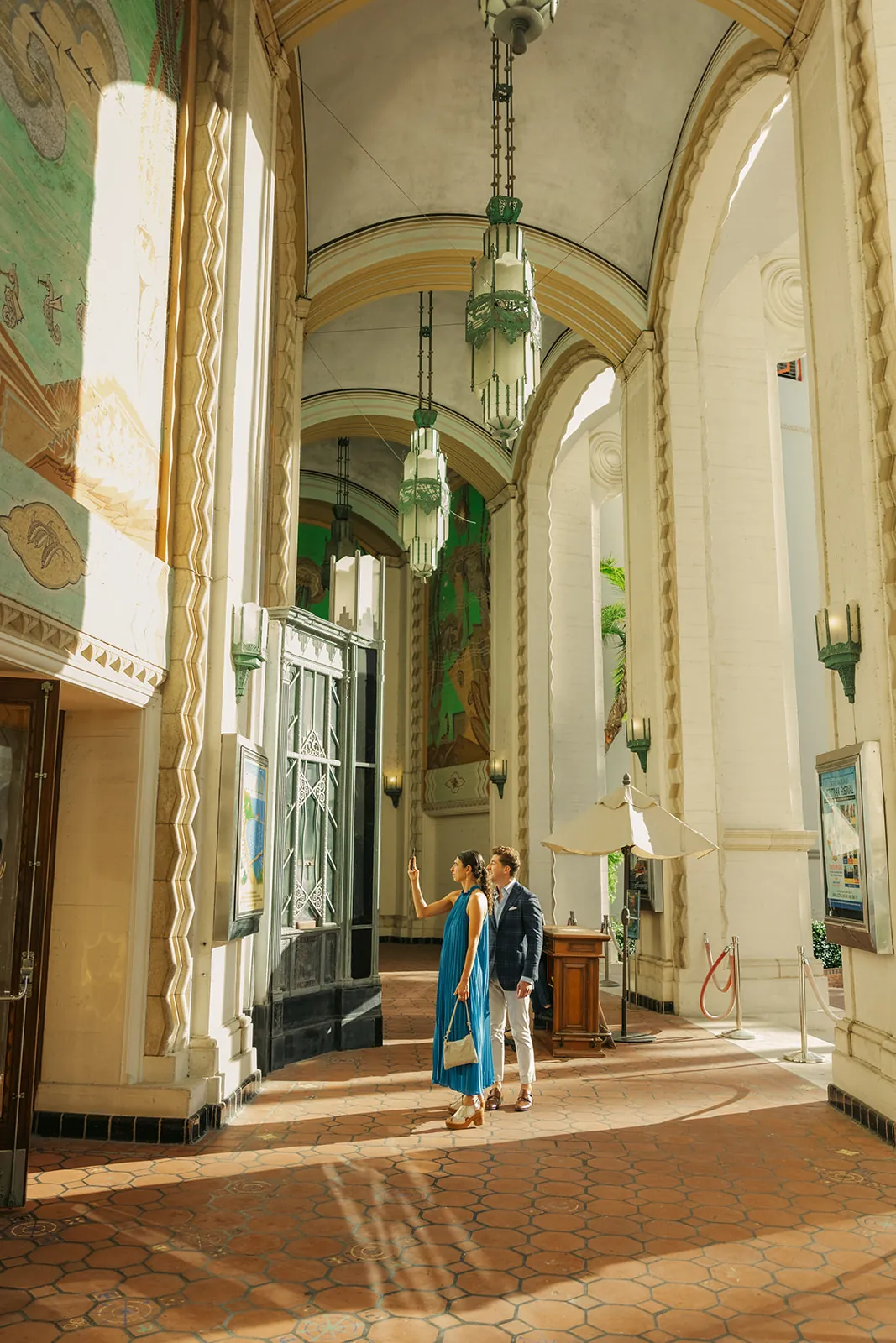 Guests looking up at the Catalina Island Casino exterior as they arrive for the wedding ceremony, Jazztrax festival poster visible on the building