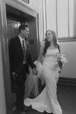 Black and white portrait of bride and groom stepping out of the historic elevator at the Old Orange County Courthouse