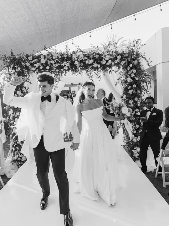 Just married couple walking down the aisle in pure joy at Los Angeles wedding photographed by documentary photographer Rene Porto