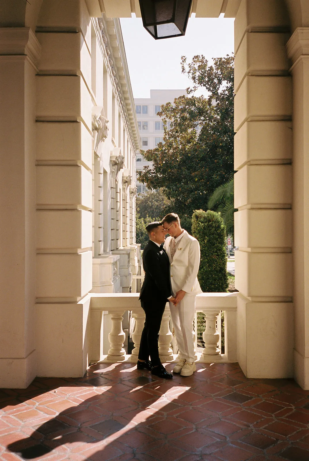Couple standing together in an exterior archway at Pasadena City Hall elopement portraits