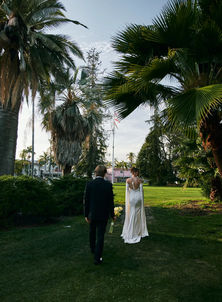 Bride and groom walking hand in hand through the gardens at the Santa Barbara courthouse