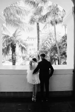Black and white portrait of bride and groom looking out the window of the Santa Barbara courthouse
