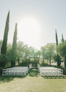 Wide view of open-air ceremony space with trees and vineyard hills beyond
