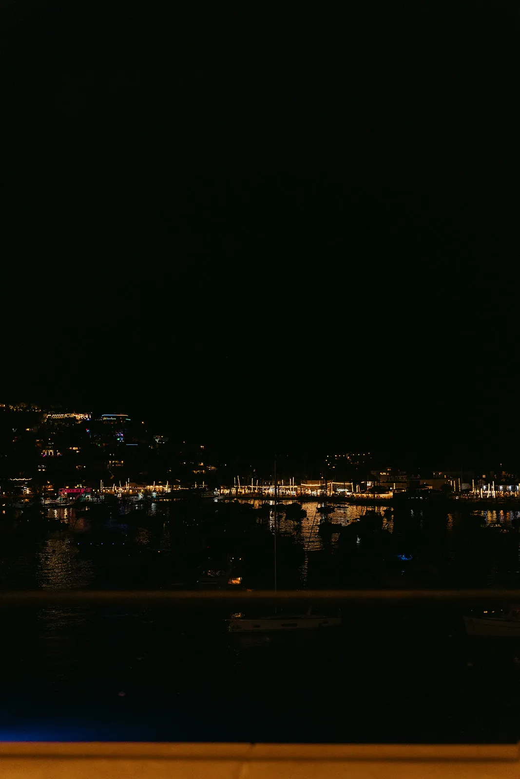 Avalon Bay at night viewed from the Catalina Island Casino veranda, city lights and marina reflected on the water