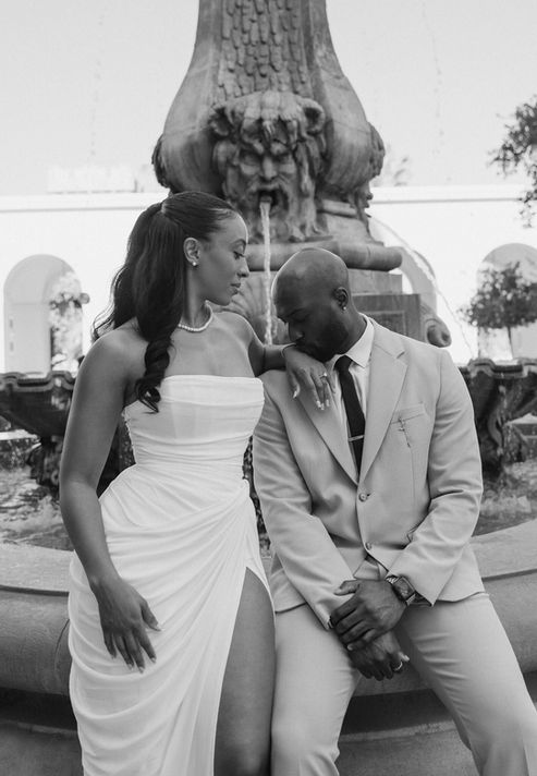 Black and white photo of bride and groom sharing a quiet moment beside the fountain at Pasadena City Hall
