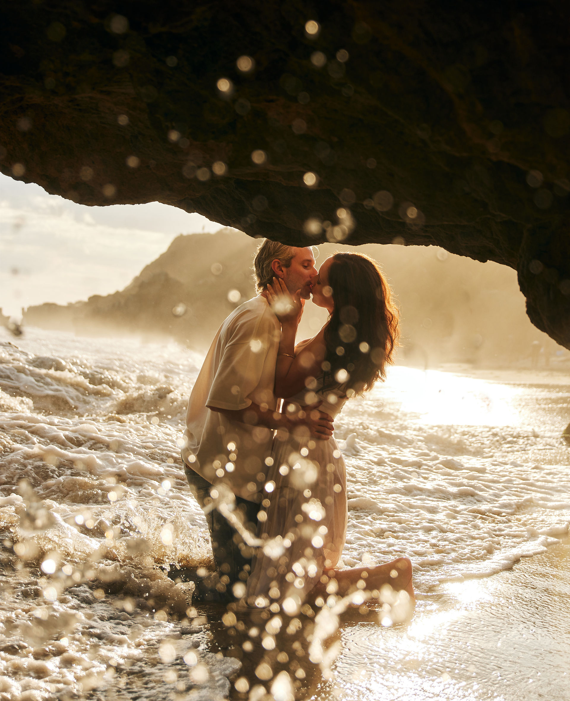 romantic malibu beach engagement photos under el matador cave at sunset with ocean waves and golden light