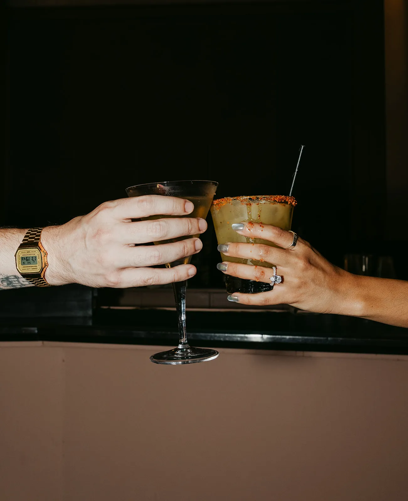 Close-up of wedding rings and cocktail glasses at the Catalina Island Casino bar during the reception