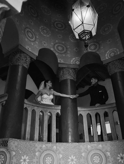 Bride and groom holding hands on the rotunda balcony at the Santa Barbara courthouse