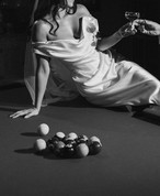 Black and white shot of Rebecca leaning across the pool table with Joshua in the groom's suite at the Ebell of Long Beach
