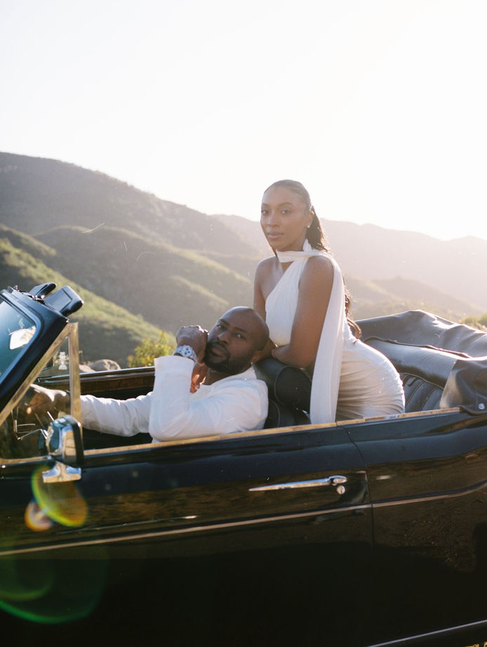 Couple laughing together inside a vintage convertible during their Malibu engagement session