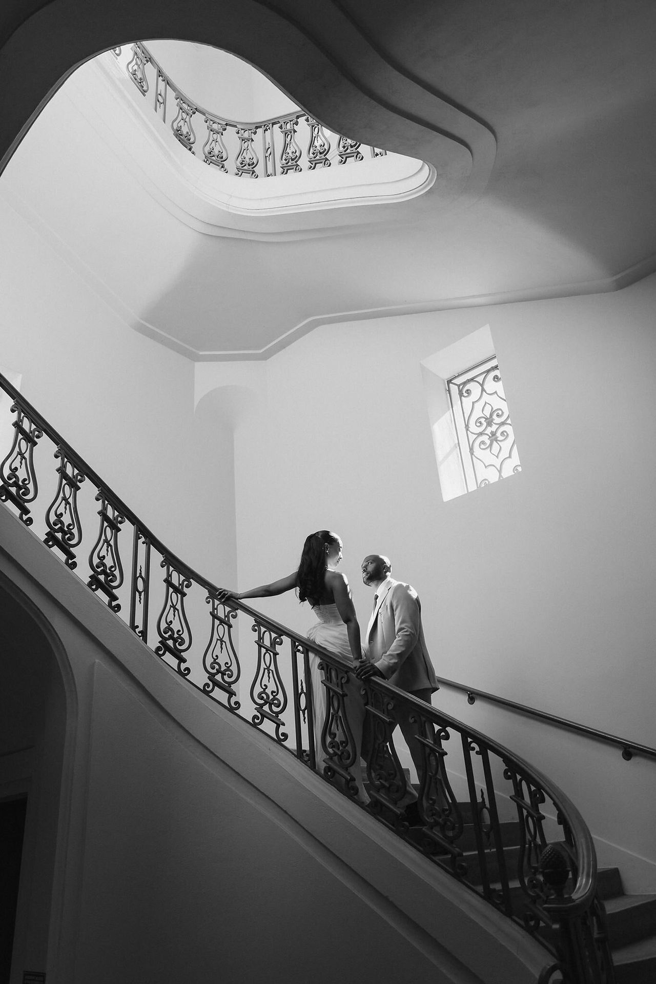 Black and white photo of a couple on the spiral staircase at Pasadena City Hall during their engagement session