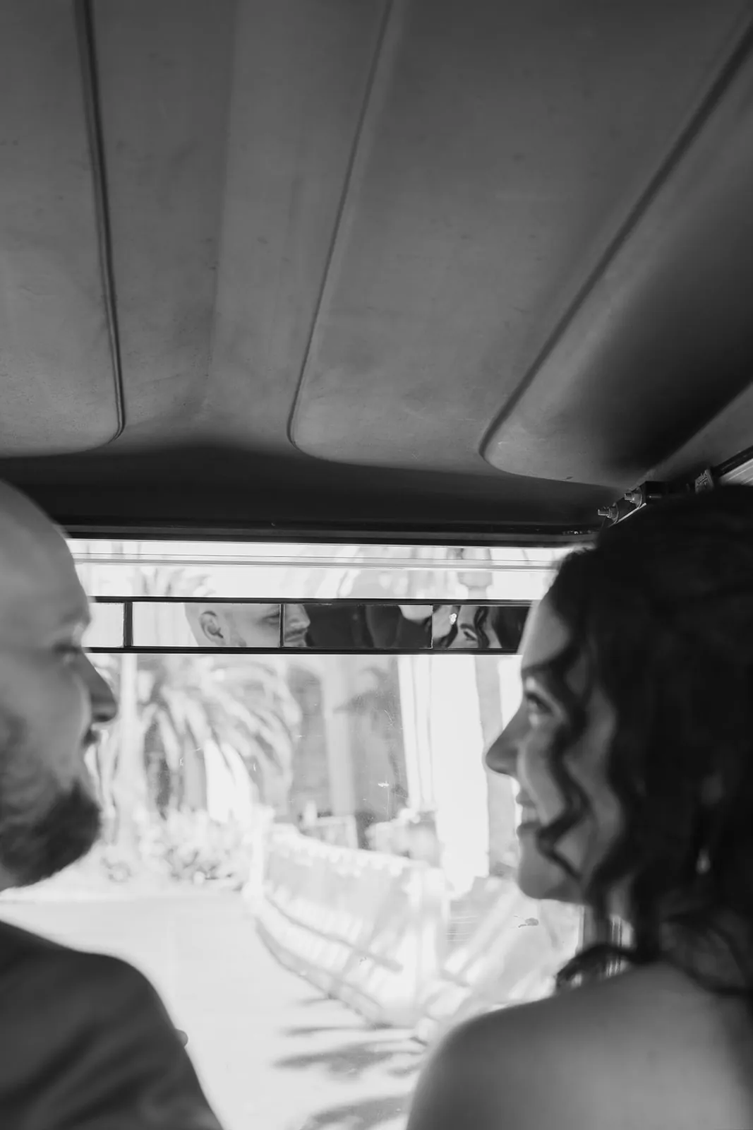 Black and white reflection of the bride and groom in a golf cart mirror as they ride through Avalon on their Catalina Island Casino wedding day