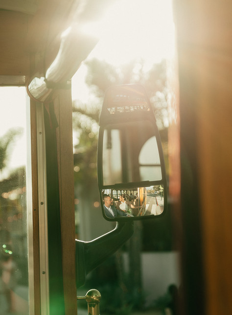 Warm golden sunlight flooding through the windows of the Santa Barbara red trolley during the wedding day ride after the Mural Room courthouse ceremony
