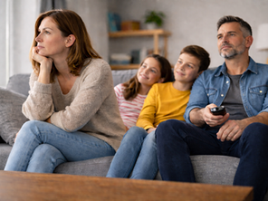 woman considering separating sitting in couch with children and husband