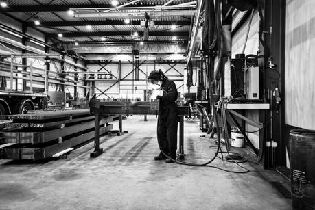 Een lasser is bezig met zijn werkzaamheden in een staalbedrijf