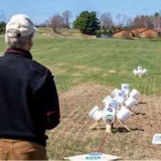 Image of an older man being given hand on training using the NIST sUAS Test Methods Open Test Lanes .