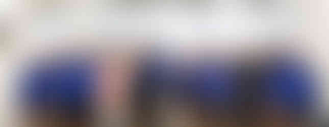 Students in uniform singing in a school library setting