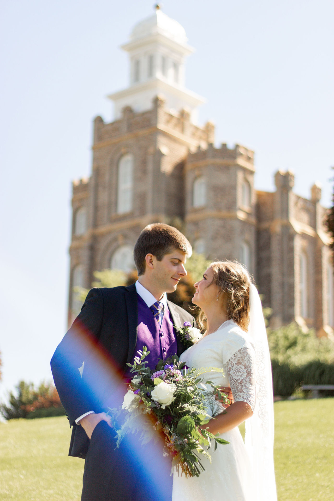 LDS Couple looking in to each other's eyes in front of the Logan Utah Temple on their wedding day