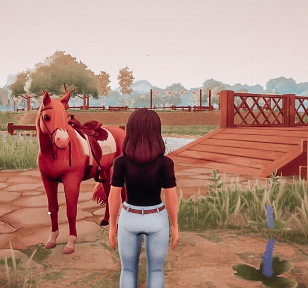 player standing beside a horse near the Ranch of Rivershine- a cozy horse game with peaceful countryside vibes.