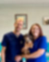 Kylie and Matt smiling and holding their puppy