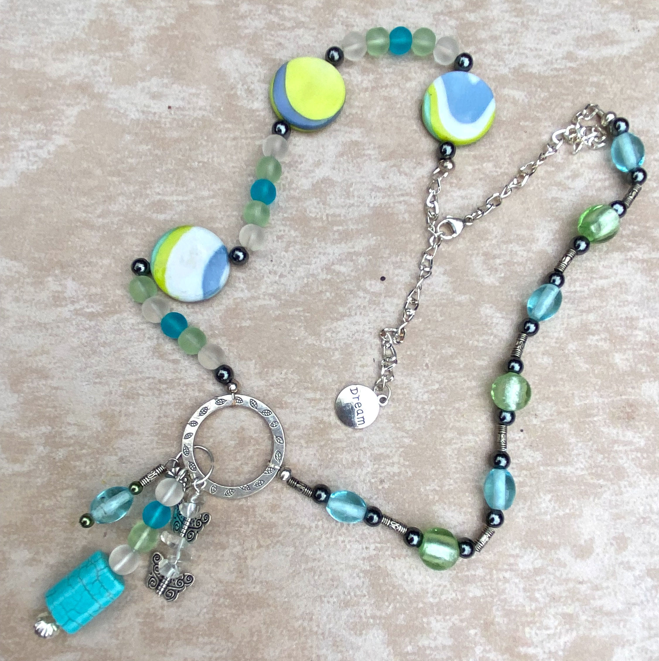 26" blue and green asymmetric necklace with charms