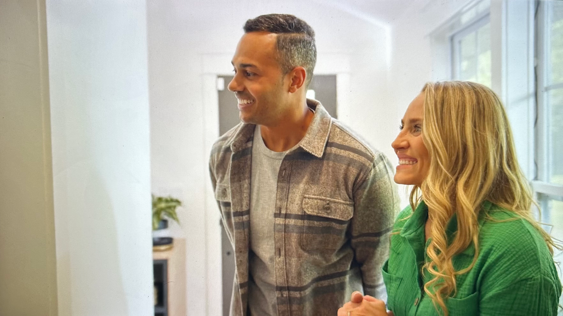 man and woman smiling looking into room