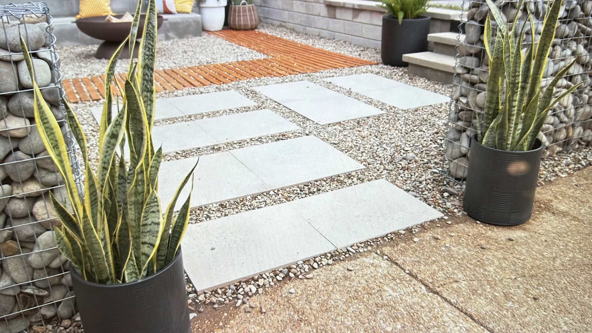large format concrete pavers that lead to an outdoor fire pit area surounded by plants