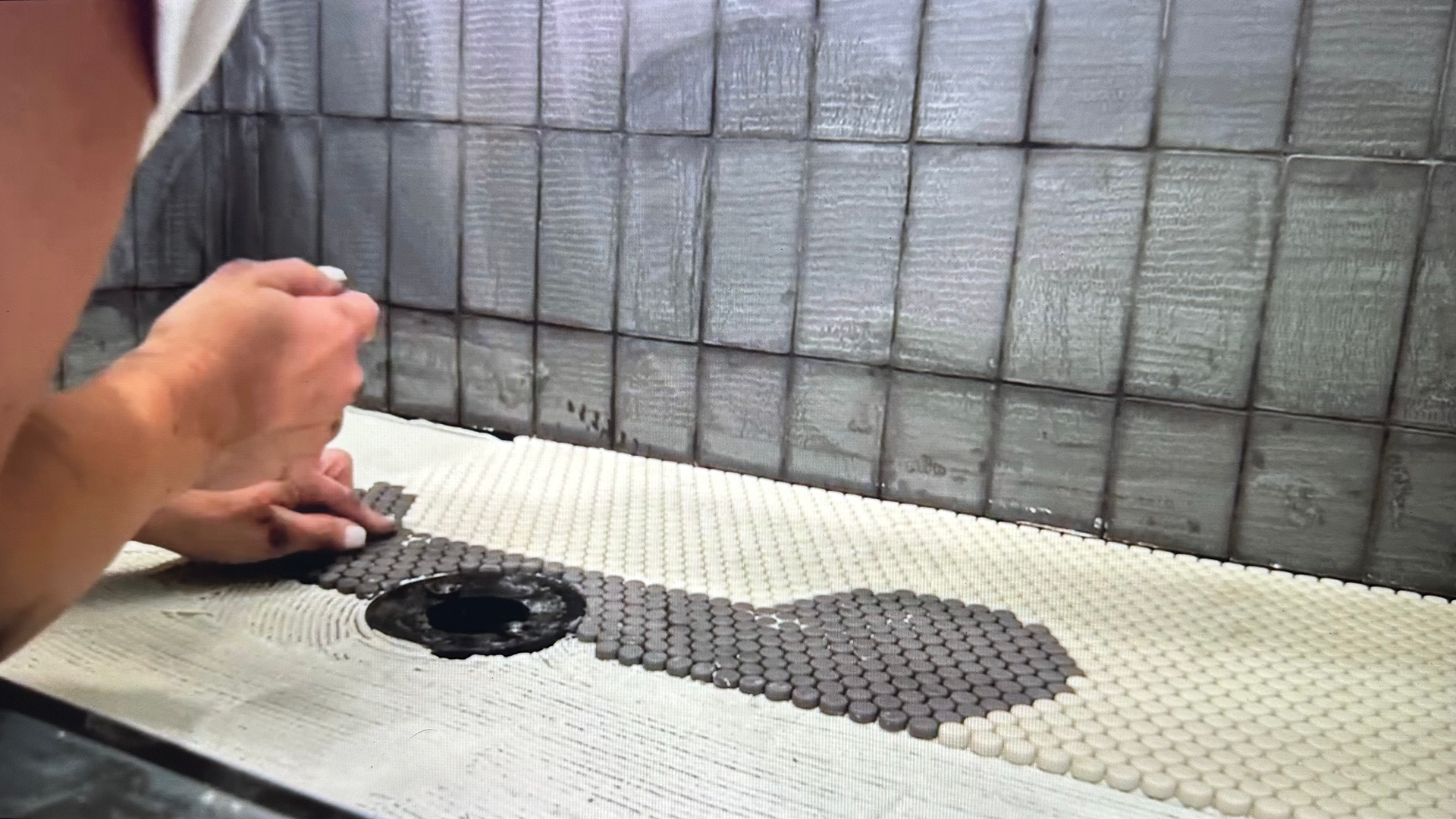 woman tiling dog washing station. dog pattern on floor is present