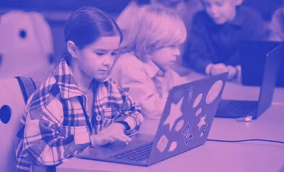 An image of students working hard on their laptops during an after school class