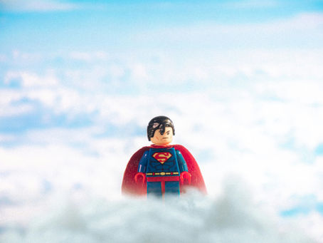 lego superman toy with clouds blue sky