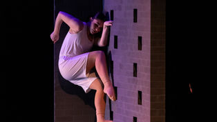 One World Production Photo (4)
A production photo featuring the "Brick Wall Set Piece". This photo features a dancer climbing the set piece.
Photo credits: Jennifer Zmuda