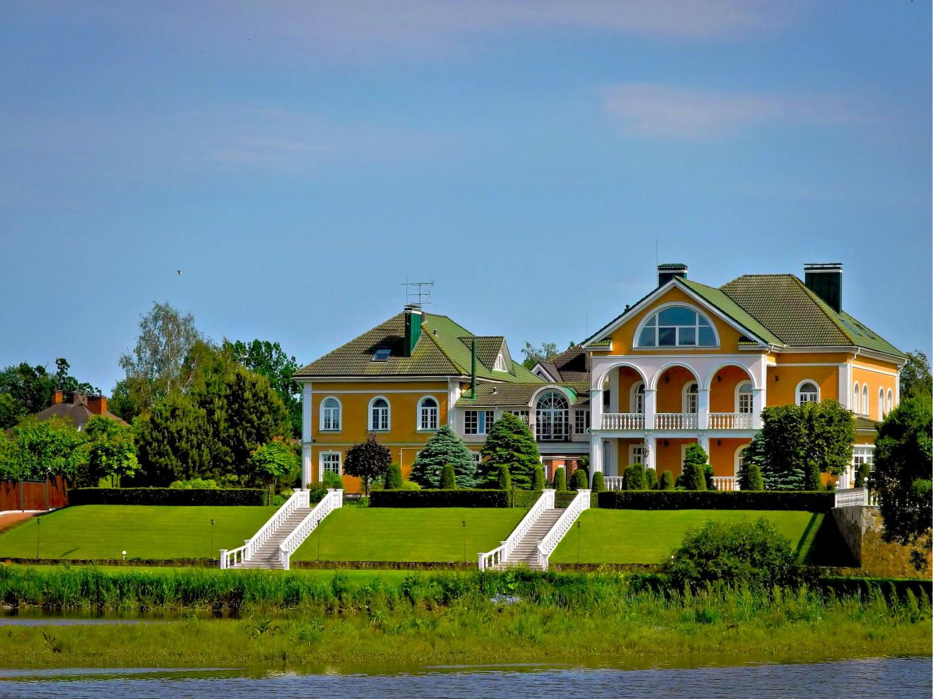 Pensiune eleganta langa lac, curte spatioasa, intretinuta, vegetatie decorativa, cer albastru