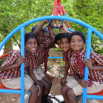 Group of Indian school kids smiling behind a swing set Jesus Way India