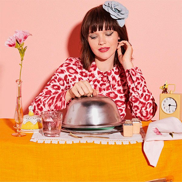 A girl sitting at a colorful  table 