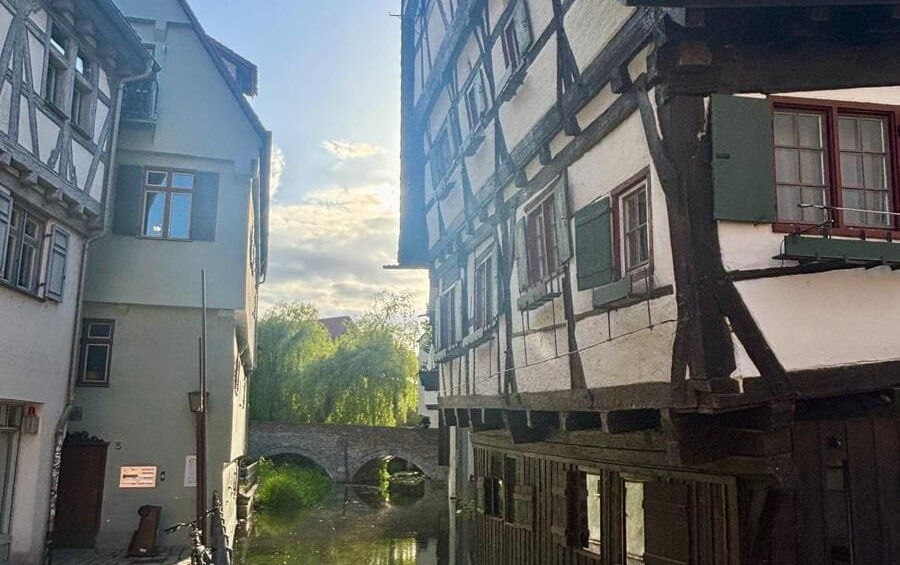 Старовинний фахверковий будинок, який сильно нахилився вбік над вузькою річкою Блау в Ульмі.