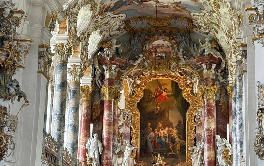 Пишний головний вівтар паломницької церкви Візкірхе у стилі баварського рококо з центральною картиною та статуями святих.