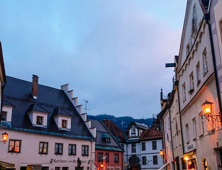 Вечірня площа у Фюссені з видом на Gasthaus zum Schwanen та бруківку.