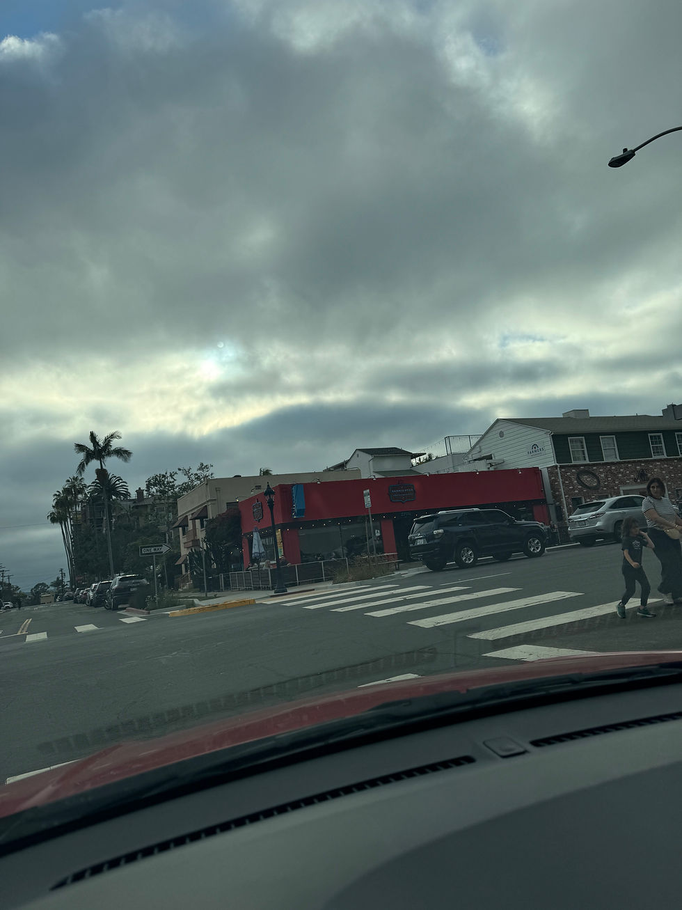 A city intersection with a red building on the corner 