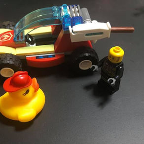the firefighter let him wear his hat as he showed him the new buggy with water canon